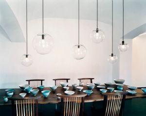Un esempio di una serie di sospensioni sul tavolo da pranzo, uguali, ma di dimensioni e posizionate ad altezze diverse, creano un piacevole effetto movimentato e azzerano l'effetto-interrogatorio di un unico lampadario.